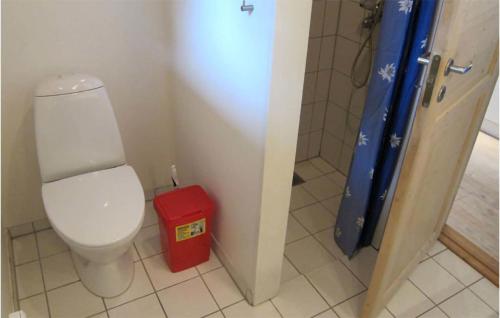 uma casa de banho com um WC e uma lata de lixo vermelha em 3 Bedroom Nice Home In Aakirkeby em Vester Sømarken