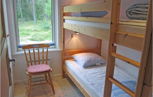 a small bedroom with a bunk bed and a chair at 3 Bedroom Nice Home In Aakirkeby in Vester Sømarken