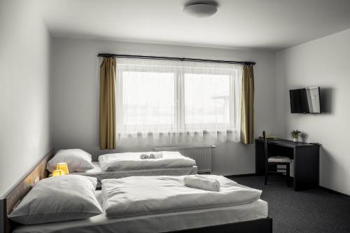 Una cama o camas en una habitación de Hotel Na Farmě Choťovice
