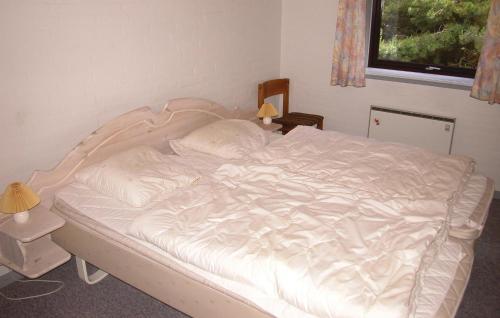 ロモ・キルケビーにあるGorgeous Home In Rm With Saunaの白いシーツと枕が備わるベッド1台