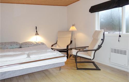 Vester Sømarken的住宿－3 Bedroom Pet Friendly Home In Aakirkeby，一间卧室配有两把椅子、一张床和窗户