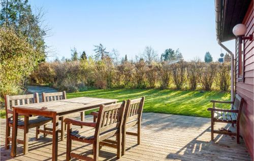 a wooden table and chairs on a deck at Gorgeous Home In Skibby With Wifi in Skibby