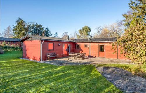 a red and orange cabin with a patio and grass at Gorgeous Home In Skibby With Wifi in Skibby