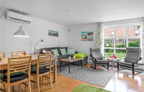 Stunning Home In Ribe With Wifi في ريبي: غرفة معيشة مع أريكة وطاولة وكراسي