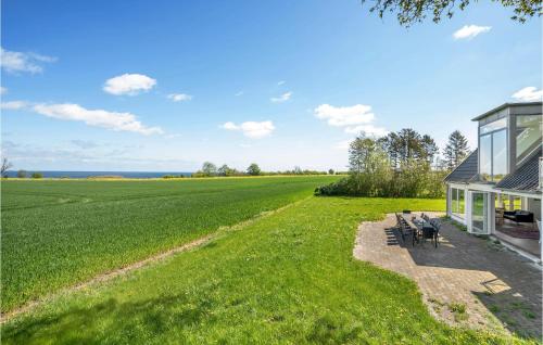 a house with a large field next to a building at Cozy Home In Store Heddinge With Wifi in Store Heddinge