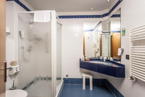 a bathroom with a sink and a toilet and a mirror at Hotel Mastai in Senigallia