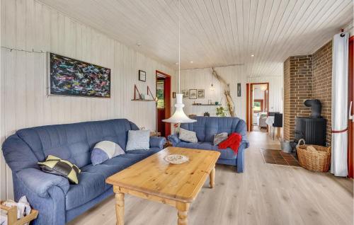 a living room with blue couches and a wooden table at Stunning Home In Hejls in Hejls