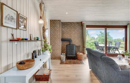a kitchen and living room with a couch and a fireplace at Stunning Home In Hejls in Hejls