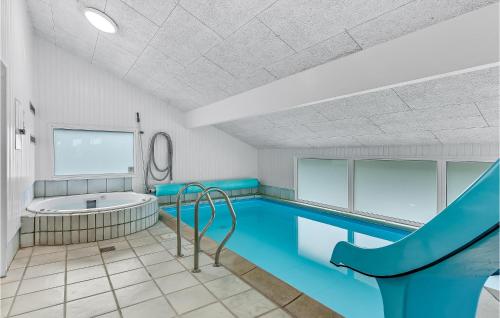 een binnenzwembad met een bad en een glijbaan bij Lovely Home In Sydals With Indoor Swimming Pool in Høruphav