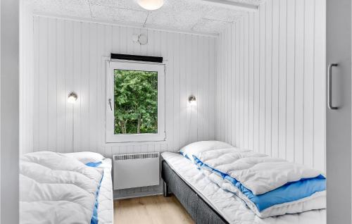 two beds in a white room with a window at Lovely Home In Sydals With Sauna in Høruphav