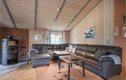 a living room with a leather couch and a table at Holiday Home Rømø 60 in Rømø