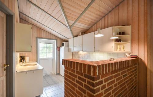 uma cozinha com uma parede de tijolos ao lado de um lavatório em Amazing Home In Rm With Sauna em Rømø Kirkeby