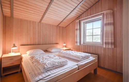 um quarto com uma cama com duas almofadas e uma janela em Amazing Home In Rm With Sauna em Rømø Kirkeby