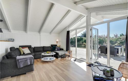 una sala de estar con un sofá y una mesa en Cozy Home In Hvide Sande With Sauna, en Bjerregård