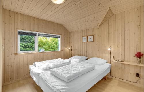 Bøtø ByにあるStunning Home In Vggerlse With 4 Bedrooms, Sauna And Wifiの窓付きの客室で、白い大型ベッド1台が備わります。
