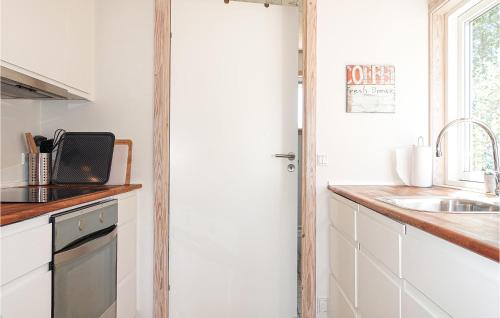 a kitchen with white cabinets and a sink at 2 Bedroom Gorgeous Home In Gudhjem in Gudhjem