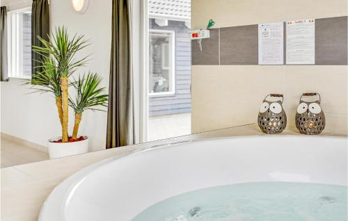 2 jarrones de búho sentados en una bañera en un baño en Nice Home In Bogense With Sauna, en Skåstrup