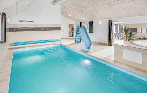 a swimming pool with a slide in a bathroom at Nice Home In Bogense With Sauna in Skåstrup