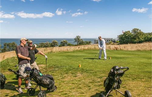 a group of people playing golf on a golf course at 2 Bedroom Gorgeous Home In Gudhjem in Gudhjem
