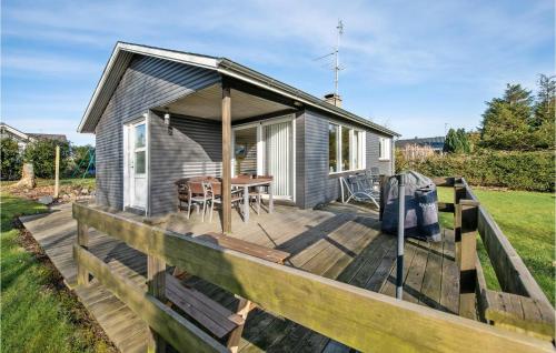 a small house on a wooden deck with a table at Lovely Home In Faaborg With Wifi in Faaborg