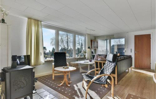 a living room with chairs and a table and windows at Lovely Home In Faaborg With Wifi in Faaborg