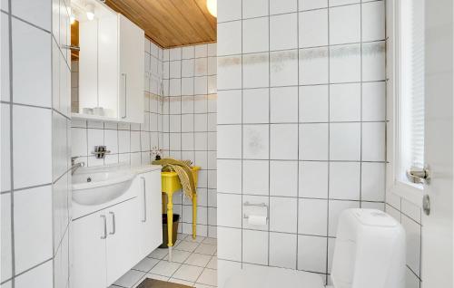 ein weiß gefliestes Bad mit einem Waschbecken und einem WC in der Unterkunft Beautiful Home In Asperup With 3 Bedrooms And Wifi in Asperup