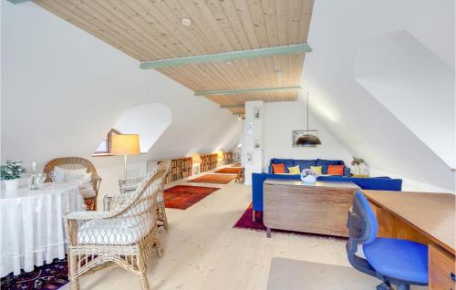 a living room with a blue bed and a table at Cozy Home In Præstø With Kitchen in Præstø