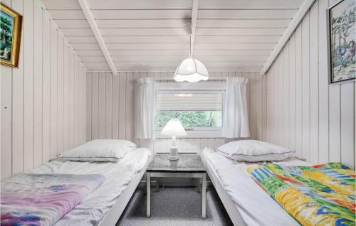 2 camas en una habitación con mesa y ventana en 3 Bedroom Stunning Home In Grlev en Gørlev
