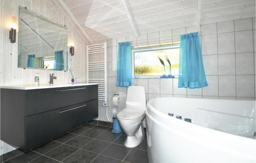a bathroom with a tub and a toilet and a sink at Bim in Fanø