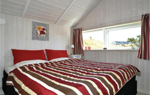 a bedroom with a bed with red pillows and a window at Bim in Fanø