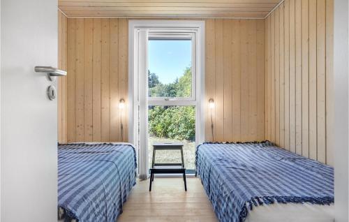 two beds in a room with a window at Lovely Home In Grenaa With Kitchen in Grenå