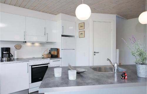 ロッケンにあるAmazing Home In Lkken With Wifiの白いキャビネットとシンク付きのキッチン