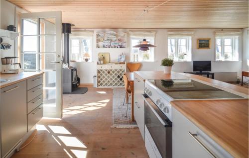 ボアディングボーにあるAmazing Home In Vordingborg With 2 Bedrooms And Wifiの白いキャビネット付きのウッドフロアのキッチン