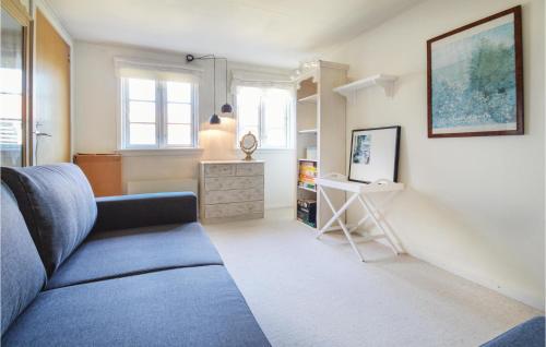 a living room with a blue couch and a table at Two-Bedroom Holiday Home In Vordingborg in Vordingborg