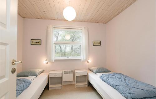 two beds in a room with a window at Fyrrebakken in Spidsegård
