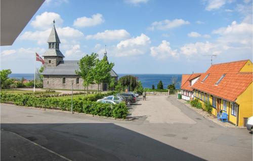 a church and cars parked in a parking lot at 1 Bedroom Amazing Apartment In Gudhjem in Gudhjem