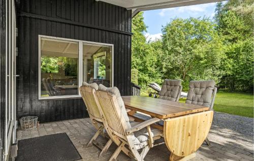 a wooden table and chairs on a patio at Beautiful Home In Nykøbing Sj With Wifi in Nyrup