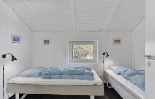a bedroom with two beds and a window at Beautiful Home In Ringkbing With 5 Bedrooms, Sauna And Indoor Swimming Pool in Søndervig