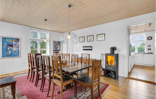 a dining room with a table and a fireplace at Six-Bedroom Holiday Home In Bagenkop in Bagenkop