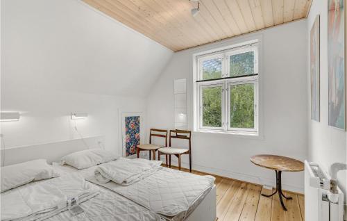 1 dormitorio con 1 cama, mesa y sillas en Awesome Home In Bagenkop With Kitchen, en Bagenkop