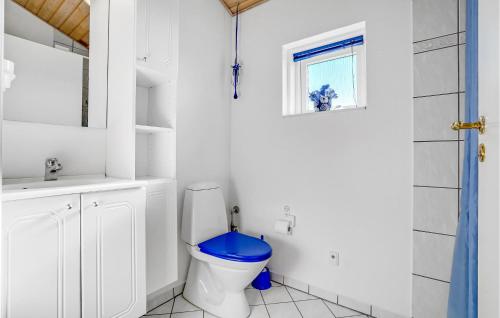 a bathroom with a toilet with a blue seat at Nice Home In Rønde With House Sea View in Rønde