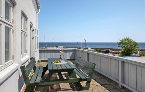 ein Picknicktisch auf einem Balkon mit Blick auf das Meer in der Unterkunft Apartment Strandpromenaden Allinge X in Allinge