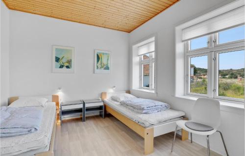 Pokój z 2 łóżkami i 2 oknami w obiekcie 2 Bedroom Gorgeous Apartment In Allinge w mieście Allinge