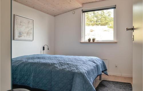 - une chambre avec un lit bleu et une fenêtre dans l'établissement 3 Bedroom Nice Home In Hvide Sande, à Bjerregård