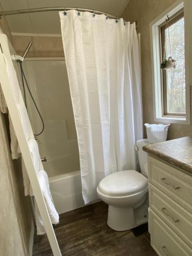 a bathroom with a toilet and a shower curtain at Your Own Cozy Tiny Home in Austell