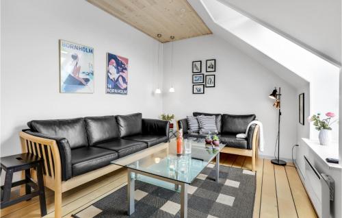 a living room with a black leather couch and a glass table at Cozy Apartment In Gudhjem With Wifi in Gudhjem