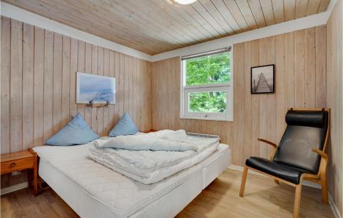 a bedroom with a bed and a chair in it at Awesome Home In Glesborg With 3 Bedrooms And Wifi in Fjellerup Strand