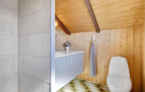 a bathroom with a white toilet and a wooden ceiling at Beautiful Home In lsted With Kitchen in Ølsted