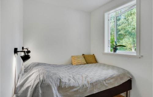 Ce lit se trouve dans un dortoir blanc doté d'une fenêtre. dans l'établissement 2 Bedroom Cozy Home In Stenlille, à Ruds-Vedby