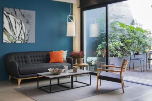 uma sala de estar com um sofá e uma mesa em Hôtel La Cour Carrée Bordeaux Centre em Bordeaux